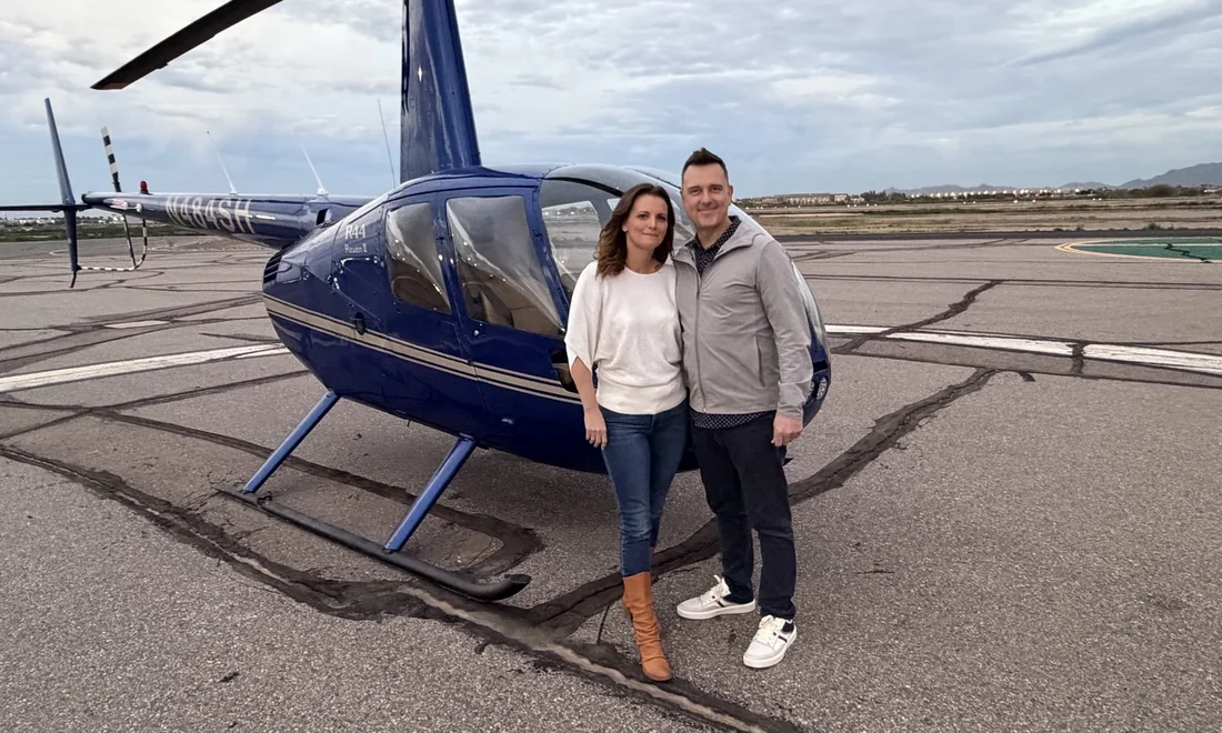 Amy and Karl beside a helicopter before an adventure